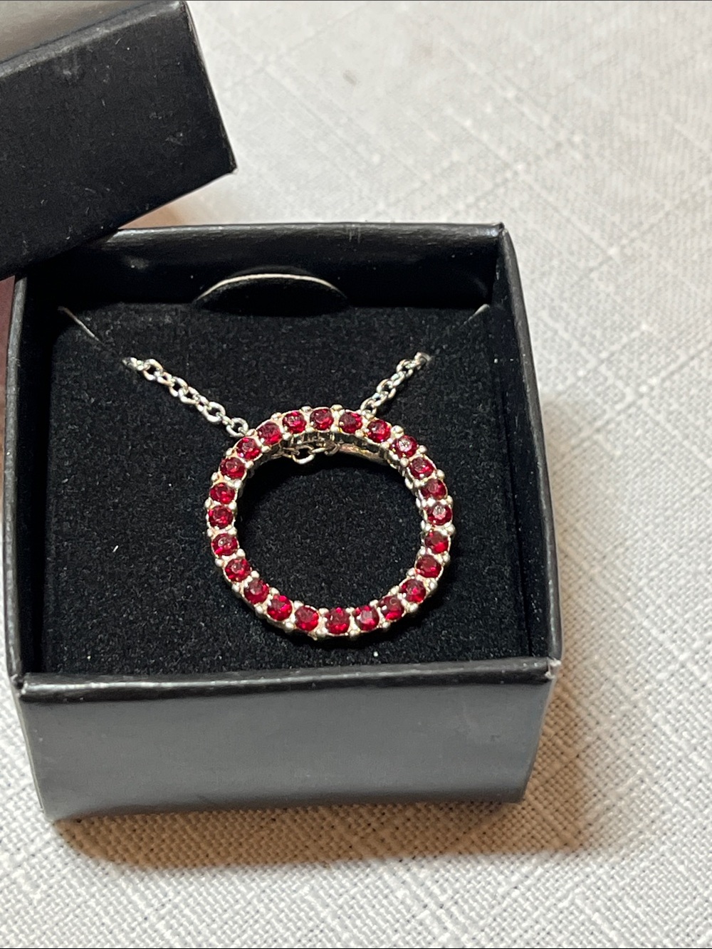 New Avon Silver-Tone Circle Pendant with Red Crystals
Box included
